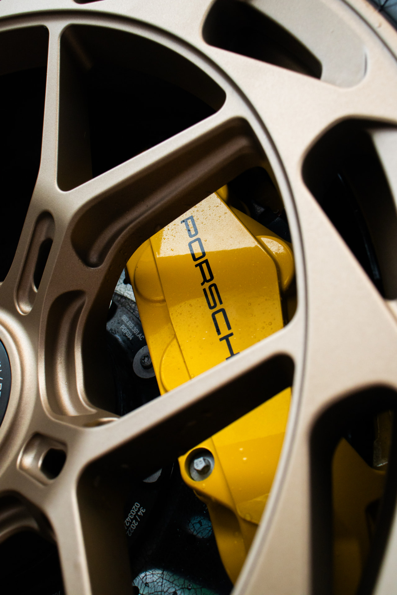 Bronze forged Porsche wheel with a yellow ceramic brake caliper