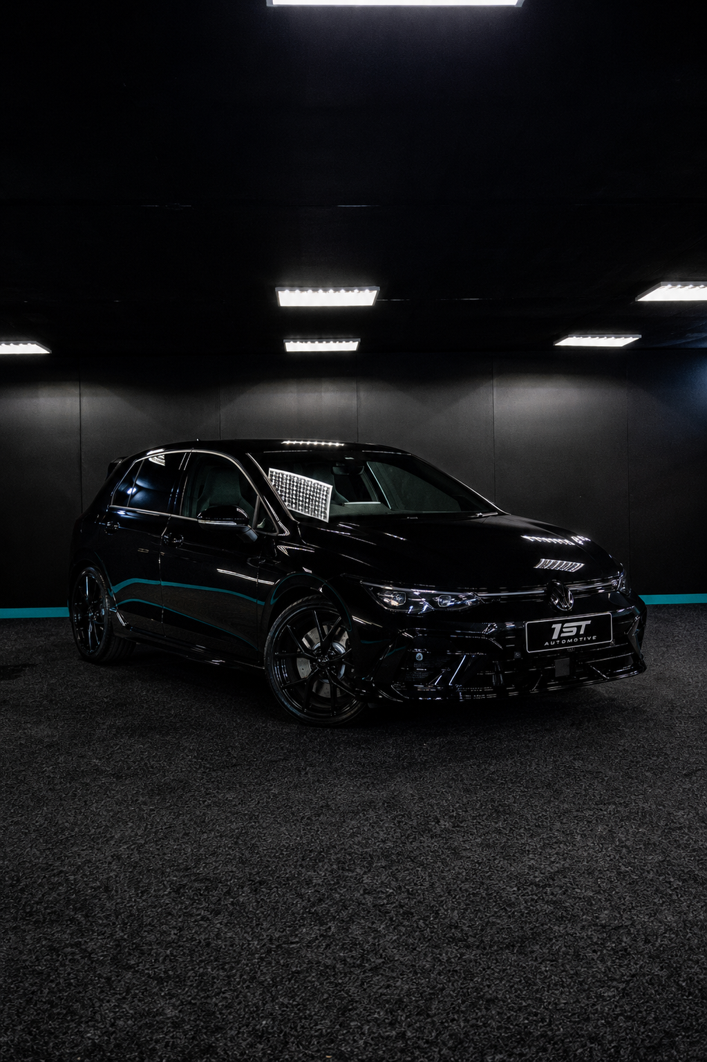 Gloss black Volkswagen Golf R under studio lighting after correction